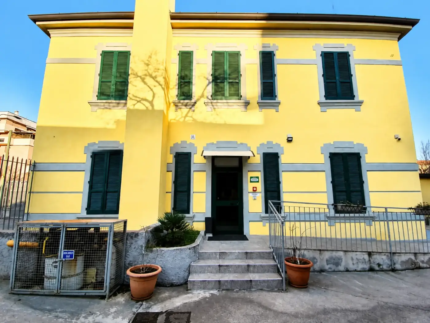 Yellow facade and main entrance of Hotel Oregon in Milan